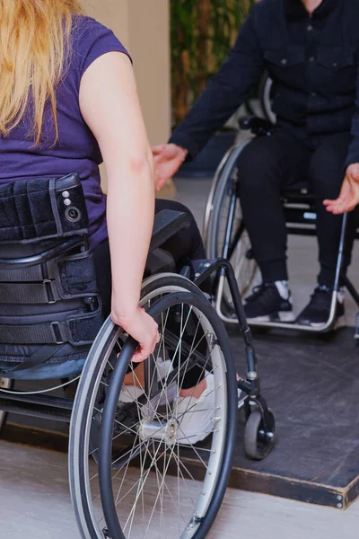 rehabilitation instructor teaches disabled girl active wheelchair techniques ,  barrier-free environment in urban space