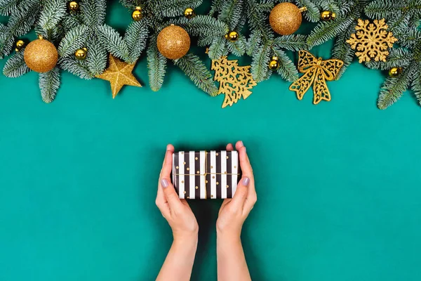 Fondo verde de Navidad con las manos y el regalo . — Foto de Stock