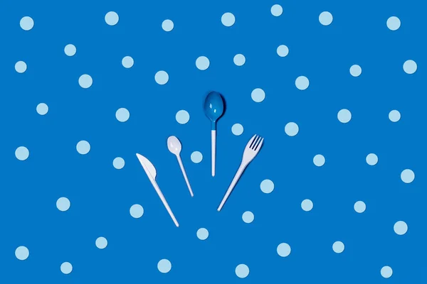 Picture of white disposable Cutlery on blue background.