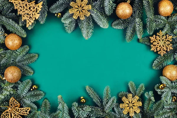 Рождественский зеленый фон с елкой и золотыми игрушками. — стоковое фото