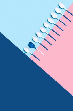 Üç renkli arkaplanda plastik kaşıklar.