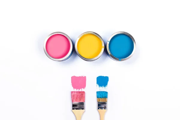 White background with three colored paint jars and brushes. — ストック写真