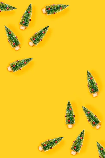Gelber Hintergrund mit Weihnachtsbäumen. — Stockfoto