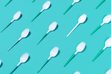 Renk arkaplanında plastik kaşıklar.