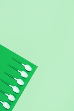 Mavi arkaplanda beyaz plastik kaşıkların resmi.