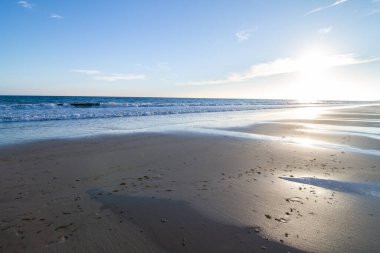 Güneş batarken ıssız bir sahil.