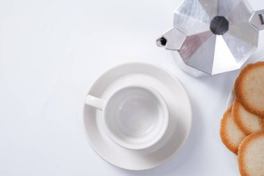 Kahve makinesi, beyaz arka planda beyaz kahvaltı fincanı ve kurabiyeler.