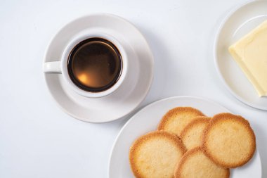 Beyaz arka planda kurabiyeli bir fincan kahve.