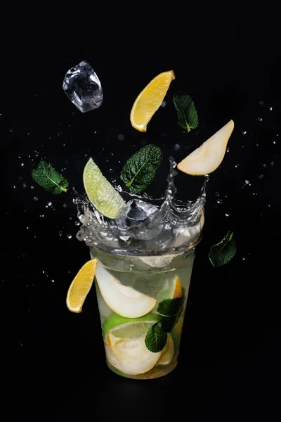 Buz küpleri limon, limon ve naneli limonata bardağına sıçrıyor.