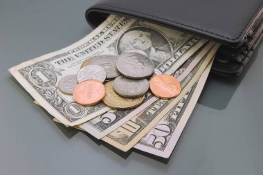 Amerikan doları, bir cüzdanın içinde çeşitli dolar banknotları ve bozuk paralar, yakın plan karanlık arka plan. Nakit para