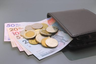 Kolombiya parası, Kolombiya parası, pesolar, cüzdanın içindeki çeşitli banknotlar ve paralar, karanlık arka planda yakın plan. Nakit para
