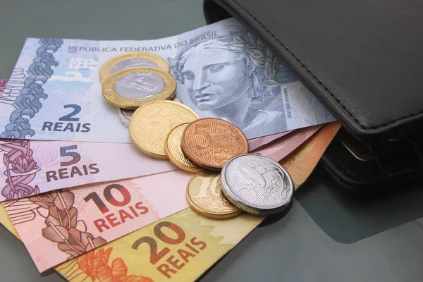 Brazilian Money, Currency of Brazil, Real, Reais, various bills and coins inside a wallet, close-up on dark background. Cash money