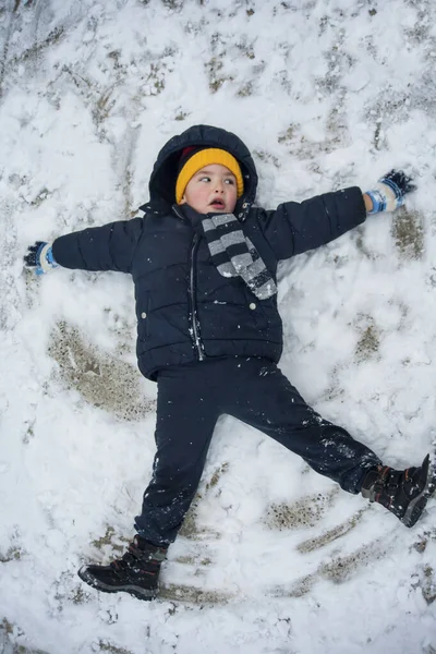 The boy lies in the snow — Stock Photo, Image