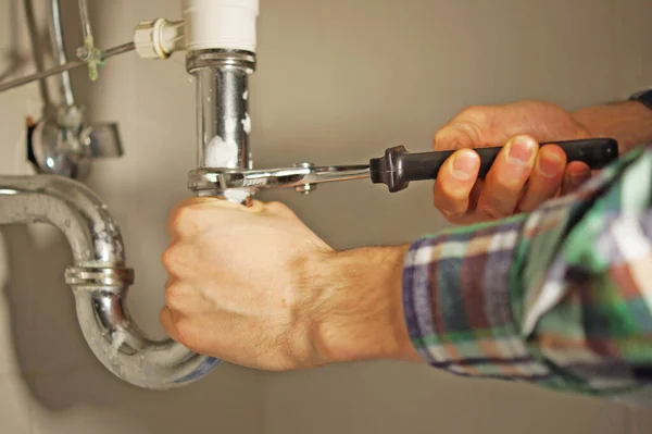 A plumber at work in the bathroom.