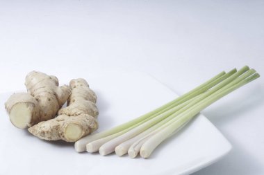 Beyaz arkaplanda zencefil kökü izole edilmiş limon sapları.
