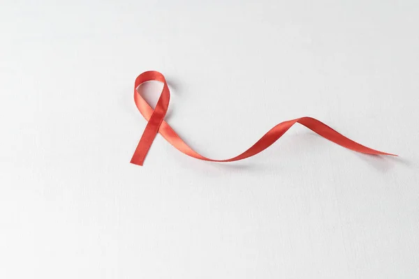 Dünya Yardım Günü ve Ulusal Hiv / Aids ve Yaşlanma Bilinci Ayı konsepti için kırmızı kurdele desteği