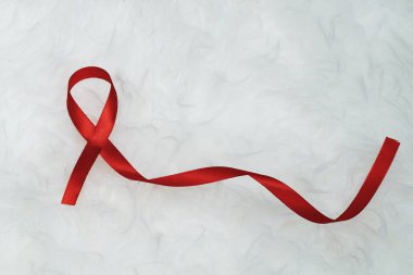 Dünya Yardım Günü ve Ulusal Hiv / Aids ve Yaşlanma Bilinci Ayı konsepti için kırmızı kurdele desteği