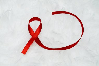 Dünya Yardım Günü ve Ulusal Hiv / Aids ve Yaşlanma Bilinci Ayı konsepti için kırmızı kurdele desteği
