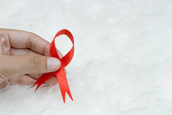 Dünya Yardım Günü ve Ulusal HIV / AIDS ve Yaşlanma Bilinci Ayı konsepti için kadınların el desteğine kırmızı kurdele takıyor