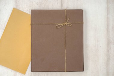 Kahverengi el işi hediye kutusu ahşap dokuma üzerinde kopya alanı, ahşap arka planda eski bir sayfa kağıt, baharat ve dekorasyon, üst görünüm, eski tarz