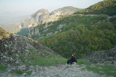 Manzaranın tadını çıkaran Asyalı gezgin, Yunanistan 'ın Varlaam kentindeki Kalampaka Tepelerinde poz verdi