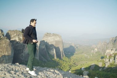 Manzaranın tadını çıkaran Asyalı gezgin, Yunanistan 'ın Varlaam kentindeki Kalampaka Tepelerinde poz verdi