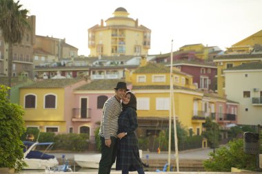Romantik Asean Müslüman çifti renkli binalara ve İspanya 'nın Valencia nehrine karşı fotoğraf çekiyor.