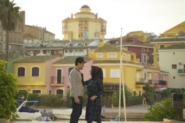 Romantik Asean Müslüman çifti renkli binalara ve İspanya 'nın Valencia nehrine karşı fotoğraf çekiyor.