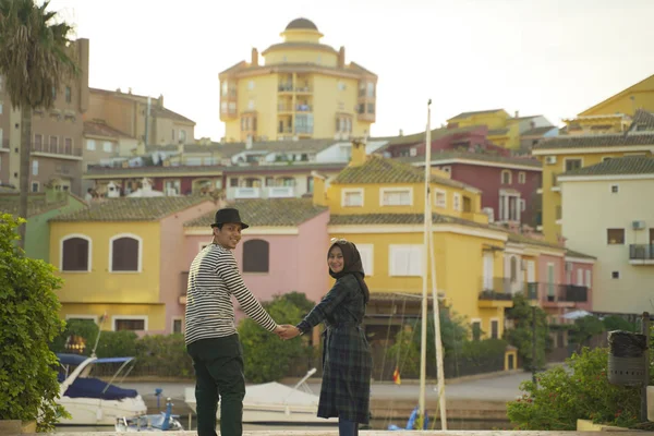 Genç Mutlu Asean Müslüman çifti renkli binalara ve İspanya 'nın Valencia nehrine karşı fotoğraf çekiyor.