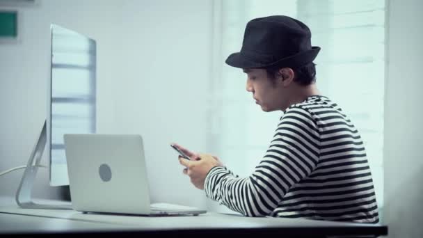 Homem Asiático Bonito Que Trabalha Casa Com Laptop Seu Smartphone — Vídeo de Stock