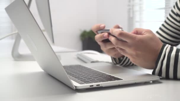 Een Jonge Man Spelen Scrollen Zijn Smartphone Tijdens Het Werken — Stockvideo