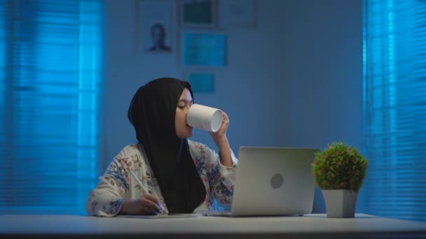 Sömniga Asiatiska Muslimer Svart Slöja Dricker Kaffe När Arbetar Hemifrån — Stockvideo