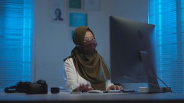 Güzel, Müslüman Asyalı bir kadın, gece evde çalışırken, modern iç tasarım alanında iş birliği yapıyordu.