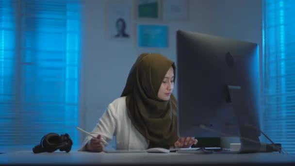 어두운 머리쓰개를 착용하고 집에서 때즐겨 아시아 이슬람교도의 부드러운 창문에서 파란색 — 비디오