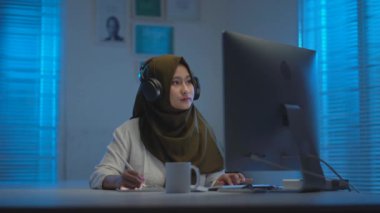 Koyu renk başörtüleri takan, evde çalışırken kulaklıkla müzik dinleyen ve geceleri dizüstü bilgisayarla çalışan Asyalı güzel Müslümanların yumuşak odağı.