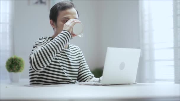 Nenucený Asijský Mladý Muž Pití Šálek Kávy Během Práce Doma — Stock video