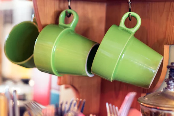 Две зеленые кофейные кружки повешены на кухне, естественное освещение . — стоковое фото