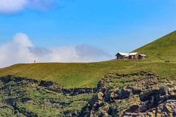 A guest house on the top of a cliff the Bjarnarey island next Heimaey, Iceland
