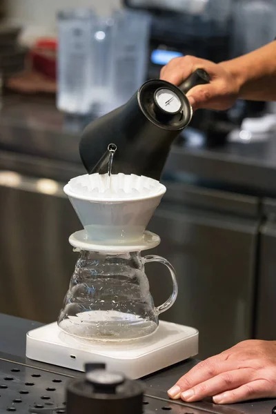 Barista mano masculina vertiendo agua caliente en un gotero para hacer café de filtro — Foto de Stock
