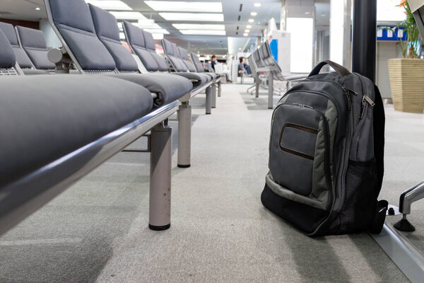 Unattended cabin backpack abandoned on the floor at airport.