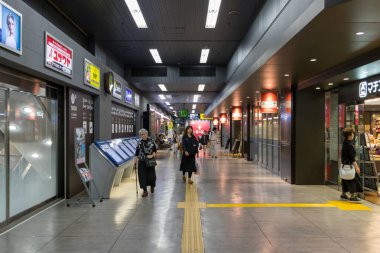 Japonya 'daki Hiroşima otobüs merkezinde yürüyen Japon yolcular..