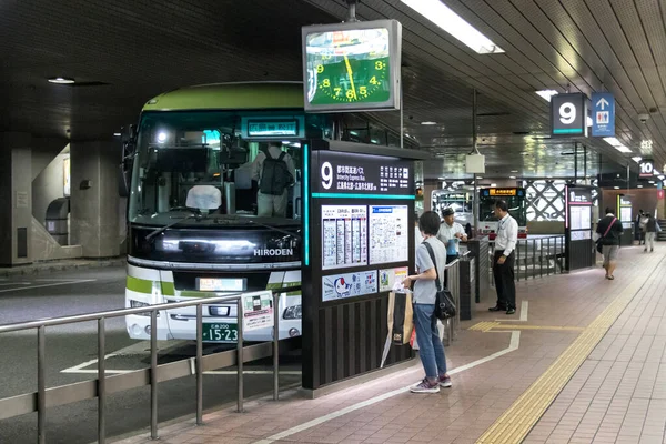 Pasajera japonesa mirando el horario en el centro de autobuses de Hiroshima, Japón . — Foto de Stock