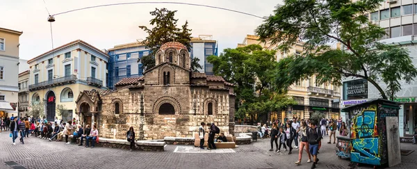 People sitting around the old church of Panagia Kapnikarea in Monastiraki, Greece — Stock Photo, Image