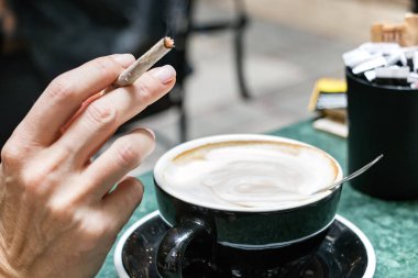 Kahve dükkanında sigara içen bir kadın.