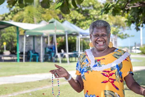 Portrét melanesiánky - australská dospělá žena se usmívá, venku. — Stock fotografie