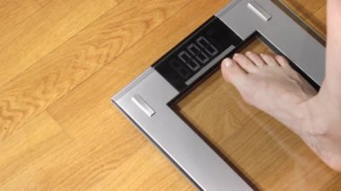 Ağırlığı dijital ölçekte denetleyen kadın, yakın çekim, perspektif.