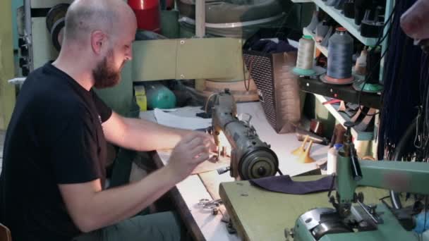 Ein Schuhmacher näht Leder mit einer alten Nähmaschine. — Stockvideo