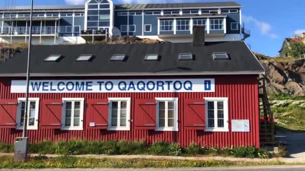 Die Willkommenstafel in einem Reisebüro und farbige Häuser an der Küste von Qaqortoq, Grönland. — Stockvideo