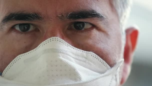 Retrato de un hombre maduro con una máscara protectora que mira a la cámara, preocupación, concepto de virus corona — Vídeo de stock