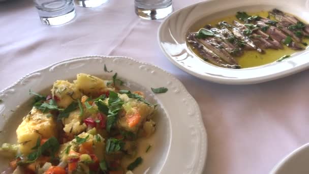 Ensalada de patata griega y pescado Gavros con pan con aceite de oliva, cámara panorámica . — Vídeos de Stock